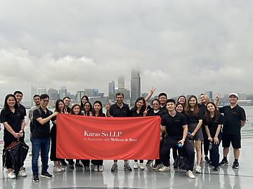 Karas So team holding Karas So LLP banner