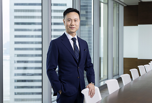 a person in a suit standing next to a table