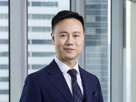 a person in a suit standing next to a table